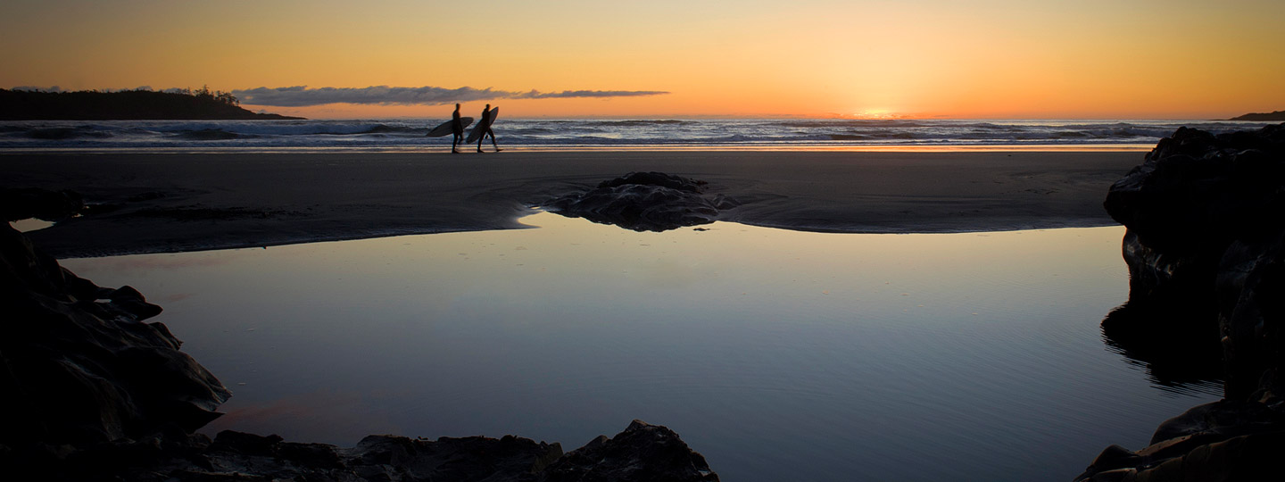 Stay Tofino - Surfers on the beach at sunset
